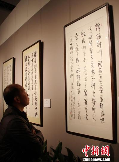 参观者正在欣赏中国书法家协会主席张海书写的一等奖获奖作品《临江仙