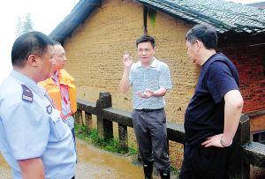区委书记张国旺(右二)在灾区部署人员撤离工作(廖晨星摄)