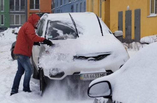 乌克兰遭受寒流袭击，大雪覆盖了当地居民的汽车。