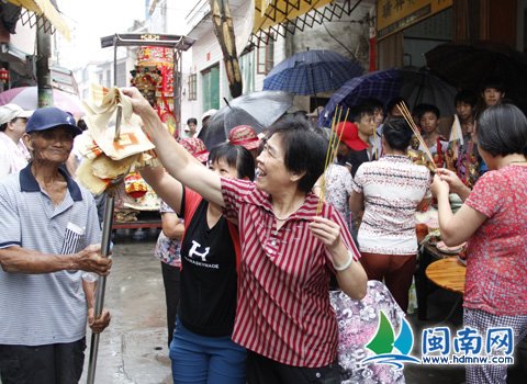 信众将纸钱插到三叉上,祈祷小孩身体安康