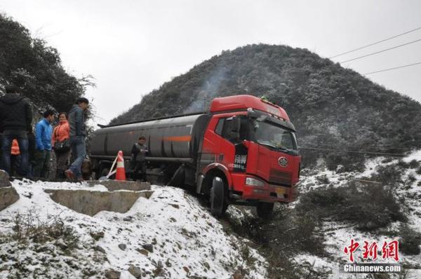 贵州公路雪凝 油罐车遇险悬在半空