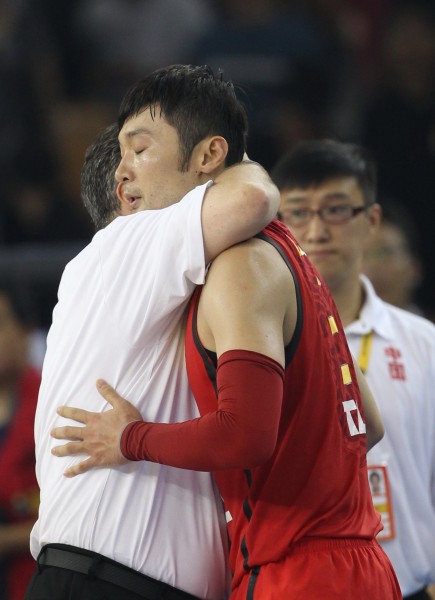 9月24日,中国队球员刘炜(中)与主教练邓华德在比赛即将结束时拥抱